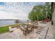 Outdoor stone patio has ample seating areas, including a fire pit, and overlooks the lake at 8170 Bay Pointe Dr, Denver, NC 28037
