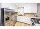 Well-lit kitchen featuring stainless steel appliances, white cabinets, tiled backsplash, and durable laminate flooring at 899 Wendover Rd # 29, Statesville, NC 28677
