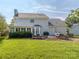 The back exterior of this home features a large yard, brick patio, and mature landscaping at 9422 Olivia Ln, Charlotte, NC 28277