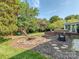 Beautiful backyard featuring a fire pit, playset, brick patio, and lush landscaping, perfect for outdoor enjoyment at 9422 Olivia Ln, Charlotte, NC 28277