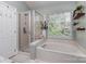 Bathroom features a glass shower enclosure, soaking tub, and natural light from the window at 9422 Olivia Ln, Charlotte, NC 28277
