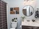 Charming bathroom with round mirror, decorative accents and patterned shower curtain at 9422 Olivia Ln, Charlotte, NC 28277