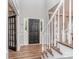 Bright foyer featuring hardwood floors, a staircase with white railings, and a black front door at 9422 Olivia Ln, Charlotte, NC 28277