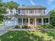 Charming two-story home featuring a welcoming front porch with white columns and manicured landscaping at 9422 Olivia Ln, Charlotte, NC 28277