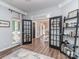 Open concept living room featuring French doors, hardwood floors, and a bookshelf at 9422 Olivia Ln, Charlotte, NC 28277