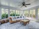 Sunroom with large windows, ceiling fan, tiled floor, and comfortable seating at 9422 Olivia Ln, Charlotte, NC 28277