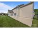 Spacious backyard and patio featuring green grass, solar panels, and neutral siding at 9937 Violet Cannon Nw Dr, Concord, NC 28027