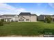 Fenced backyard with solar panels on roof and a large grass lawn at 9937 Violet Cannon Nw Dr, Concord, NC 28027