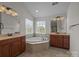 The bathroom showcases double sinks, a large soaking tub, and tiled floors at 9937 Violet Cannon Nw Dr, Concord, NC 28027