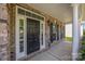 Inviting front porch featuring a black front door with white trim, and brick facade at 9937 Violet Cannon Nw Dr, Concord, NC 28027