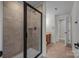 Walk-in shower features a glass door, neutral-colored tile, and chrome fixtures at 9937 Violet Cannon Nw Dr, Concord, NC 28027