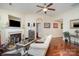 Living room with a fireplace, large window, hardwood floors, and comfortable furniture at 10211 Dominion Village Dr, Charlotte, NC 28269