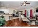 Open-concept living room features hardwood floors, a cozy fireplace, and seamless flow into the dining area at 10211 Dominion Village Dr, Charlotte, NC 28269