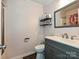 Bathroom with dark vanity, toilet, tile flooring, shower, and shelves at 12423 Softwood Ct, Charlotte, NC 28273