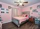 Pink bedroom with hardwood floors, a ceiling fan, and a full size bed at 12423 Softwood Ct, Charlotte, NC 28273