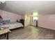 Pink bedroom with hardwood floors, a window AC unit, and a full size bed at 12423 Softwood Ct, Charlotte, NC 28273