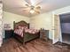 Bedroom with a decorative bed, hardwood floors, a ceiling fan, and a door to the outside at 12423 Softwood Ct, Charlotte, NC 28273
