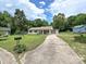 Cozy single-story home featuring a long driveway and a well-manicured front lawn with mature trees at 12423 Softwood Ct, Charlotte, NC 28273