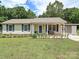 Charming single-story home with a well-maintained lawn, blue shutters, and a welcoming front porch seating area at 12423 Softwood Ct, Charlotte, NC 28273