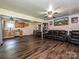 Inviting living room featuring dark wood flooring, a leather sofa, and seamless transition to the kitchen at 12423 Softwood Ct, Charlotte, NC 28273