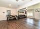 Open-concept dining and living room with hardwood floors, connected with seamless transitions to the kitchen and more at 12423 Softwood Ct, Charlotte, NC 28273