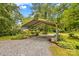 Metal carport with gravel flooring, ideal for parking, projects, or relaxing on the swing at 1321 Arbor Dr, Salisbury, NC 28144