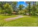 Expansive yard with mature trees, providing privacy and shade; featuring a gravel driveway at 1321 Arbor Dr, Salisbury, NC 28144