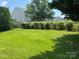 Expansive backyard with lush green grass and mature trees, providing ample space at 13409 Planters Row Dr, Charlotte, NC 28278