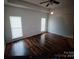 Bright bedroom showcasing hardwood floors and plenty of natural light from two windows at 13409 Planters Row Dr, Charlotte, NC 28278