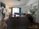 Cozy living room with a fireplace, large windows, and built-in bookshelves at 13409 Planters Row Dr, Charlotte, NC 28278