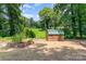 Backyard shed surrounded by lush green trees, flower beds, and an expansive lawn at 140 Fairway Ln, Gastonia, NC 28216