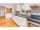 Well-lit kitchen with white cabinetry, modern appliances, hardwood floors, and stylish backsplash at 140 Fairway Ln, Gastonia, NC 28216