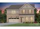 Two-story brick home with a two-car garage, charming front porch, and professionally landscaped yard at 14113 New Crest Ln # 153, Huntersville, NC 28078