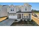 Two-story home featuring a grey exterior, two-car garage, covered porch, and well-maintained landscaping at 14113 New Crest Ln # 153, Huntersville, NC 28078