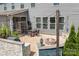 Backyard patio with fire pit, outdoor lighting, dining furniture, hardscape, and manicured lawn at 16324 Loch Raven Rd, Huntersville, NC 28078