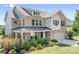 Beautiful two-story brick home featuring a covered porch, manicured landscaping, and an attached garage at 16324 Loch Raven Rd, Huntersville, NC 28078