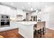 Modern white kitchen with stainless steel appliances, a large island, and hardwood floors at 16324 Loch Raven Rd, Huntersville, NC 28078