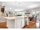 Open kitchen flows into the living room featuring a large island, stainless steel appliances, and hardwood floors at 16324 Loch Raven Rd, Huntersville, NC 28078