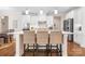 Bright, open kitchen featuring white cabinets, a large island with seating, and modern lighting at 16324 Loch Raven Rd, Huntersville, NC 28078