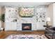 Inviting living room features a stone fireplace, built-in shelving, and hardwood floors at 16324 Loch Raven Rd, Huntersville, NC 28078