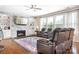 Cozy living room with stone fireplace, large windows, leather seating, and hardwood floors at 16324 Loch Raven Rd, Huntersville, NC 28078