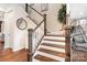 Elegant staircase with wooden railings, white risers, and hardwood flooring at 16324 Loch Raven Rd, Huntersville, NC 28078