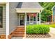 Charming front entrance with brick steps, black door with sidelights, and hanging flower baskets at 1887 Steeplechase Dr, Rock Hill, SC 29732