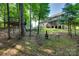 A cozy backyard setting with a rustic fire pit and treehouse, perfect for outdoor relaxation at 2205 Gallberry Ln, Waxhaw, NC 28173