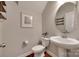 Charming powder room with pedestal sink, hardwood floors, decorative mirror and neutral color palette at 2205 Gallberry Ln, Waxhaw, NC 28173