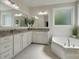 Bright bathroom with double sinks, granite counters, vanity storage and a soaking tub at 2205 Gallberry Ln, Waxhaw, NC 28173