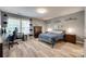 A spacious bedroom featuring wood floors, gray walls, and lots of natural light at 2205 Gallberry Ln, Waxhaw, NC 28173