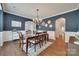 Elegant dining room with dark blue walls, crown molding, and a chandelier at 2205 Gallberry Ln, Waxhaw, NC 28173