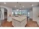 Open kitchen with large island, stainless appliances, granite counters and view to adjacent living room at 2205 Gallberry Ln, Waxhaw, NC 28173