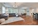 Bright, open-concept living area with hardwood floors, a sectional sofa, and large windows at 2205 Gallberry Ln, Waxhaw, NC 28173